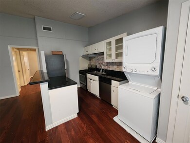 Kitchen featuring white cabinetry, glass insert cabinets, stainless steel appliances, dark countertops, and dark wood-style flooring