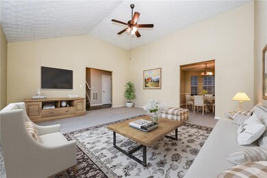 Living room with ceiling fan with notable chandeli