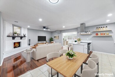 Virtual Staged, Living, Dining room, Kitchen,with ceiling fan, light tile patterned floors, recessed lighting, and a brick fireplace