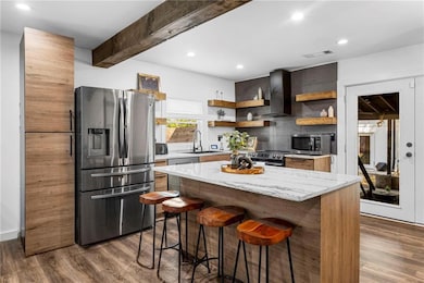 Kitchen with a breakfast bar, open shelves, visibl