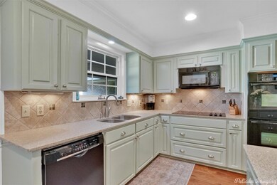 Kitchen with decorative backsplash, sink, light ha