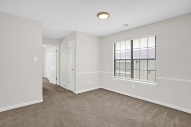 Empty room featuring carpet and baseboards