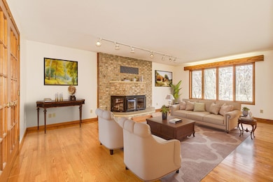 The elegant Living Room is filled with natural light. Beautiful 3-sided brick fireplace.