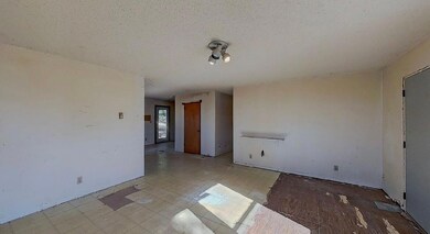 Empty room with a textured ceiling and light floor