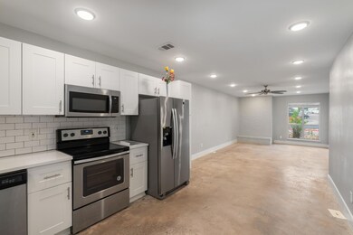 Kitchen featuring a ceiling fan, tasteful backspl