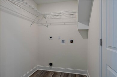 Clothes washing area with dark hardwood / wood-sty