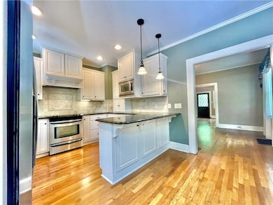 Kitchen featuring ornamental molding, stainless st