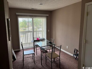 Carpeted dining space with a textured ceiling