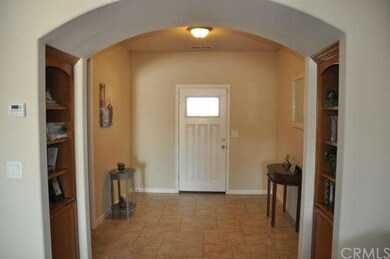 Foyer with arched entry and built in book shelves 