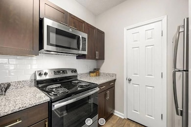 Kitchen featuring dark wood-type flooring, light s