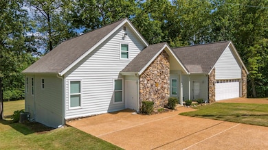 View of front facade featuring a front yard, a gar