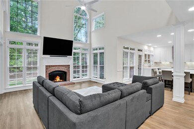 The heart of the home shines with an abundance of natural light, accentuated by dramatic windows, a cozy fireplace, and open sightlines to the serene backyard.
