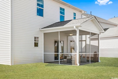 Back of property with a sunroom, a patio, and a la