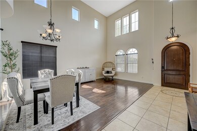 Dining area featuring a towering ceiling, a chande