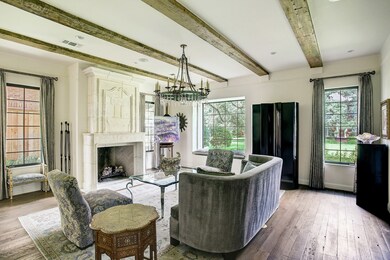 Majestic, reclaimed beams highlight the formal living room. The extensive craftsmanship and attention to detail are present throughout this home. The beautiful cast stone fireplace provides a cozy feel in this elegant yet approachable room.