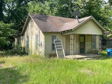View of side of home featuring roof with shingles, stucco siding, and covered porch