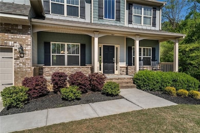 Doorway to property with stone siding and covered porch