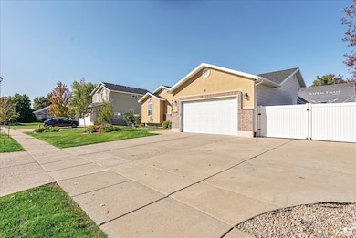 Ranch-style home with a gate, driveway, brick siding, and an attached garage