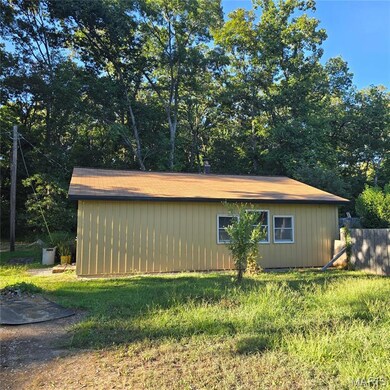 View of property exterior featuring view of wooded area