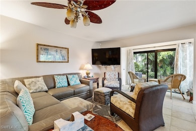 Living area with ceiling fan and light tile patter
