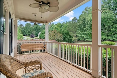 Wooden deck featuring ceiling fan and view of scattered trees