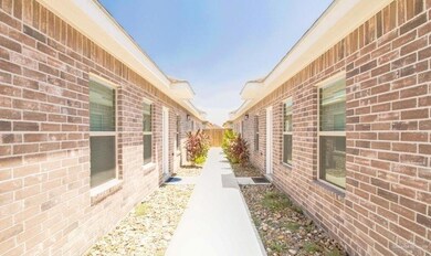 View of side of home featuring fence and brick siding