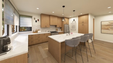 Kitchen with light stone countertops, light wood-style flooring, tasteful backsplash, decorative light fixtures, and a kitchen breakfast bar