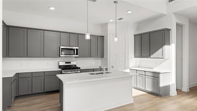 Kitchen featuring gray cabinetry, backsplash, appliances with stainless steel finishes, decorative light fixtures, and recessed lighting