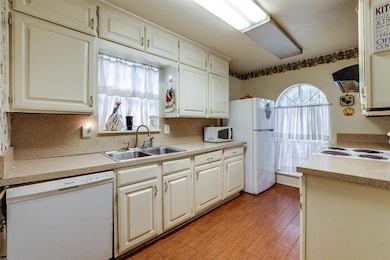 Kitchen featuring ventilation hood, sink, light wo
