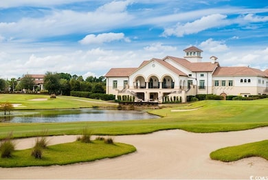 View of home's community with golf course view, a water view, and a lawn