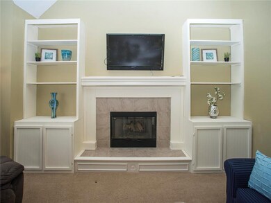 Built-in shelves frame the gas fireplace in the Gr