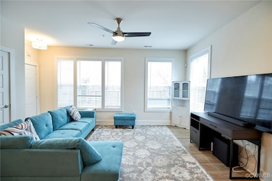 Living room featuring visible vents, baseboards, a