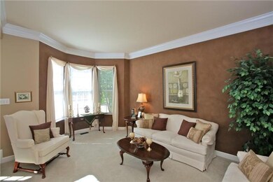Sunken formal living room with designer paint finish. Crown molding highlights the high ceiling.
