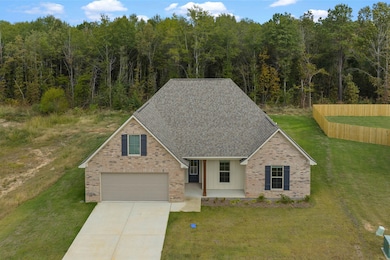 Traditional home with a shingled roof, a porch, brick siding, driveway, and board and batten siding