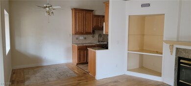 Kitchen featuring a tiled fireplace, brown cabinet