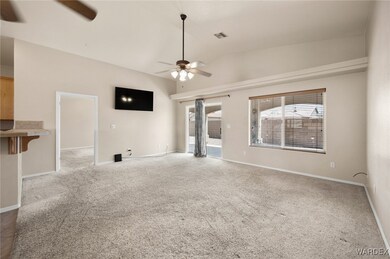 Unfurnished living room featuring ceiling fan, hig
