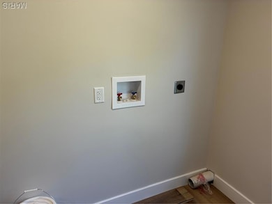 Laundry room with wood finished floors, hookup for a washing machine, and electric dryer hookup