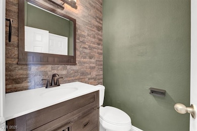 Bathroom with vanity and a textured wall