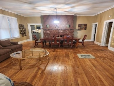 Living room with wood finished floors, crown moldi