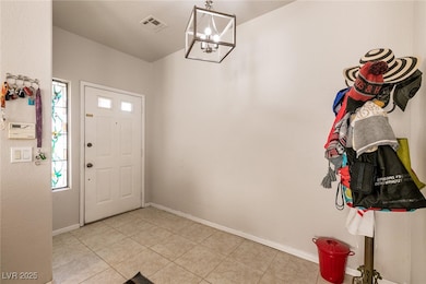 Entryway featuring a chandelier and light tile pat