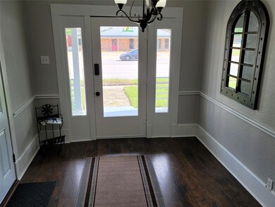 Foyer entrance with an inviting chandelier, a text