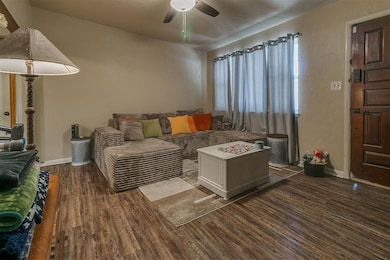 Living room with dark wood-style flooring and a ceiling fan