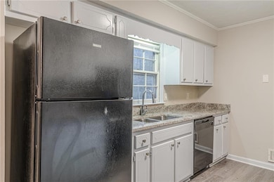 Kitchen with freestanding refrigerator, dishwasher, a sink, light wood-type flooring, and ornamental molding