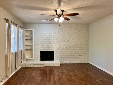Unfurnished living room featuring a brick firepla