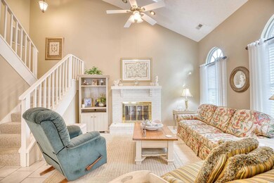 Tiled living room featuring high vaulted ceiling, 