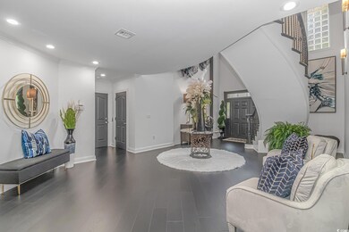 Foyer entrance featuring arched walkways, recessed lighting, wood finished floors, baseboards, and ornamental molding