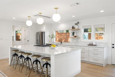 Kitchen with a center island, white cabinets, lig