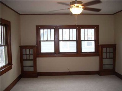 Front room with glass front bookcase built-ins.