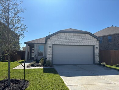 This photo shows a modern single-story home with a light brick exterior, a double garage, and a neatly landscaped front yard. The driveway is spacious, and the property is situated in a suburban neighborhood.