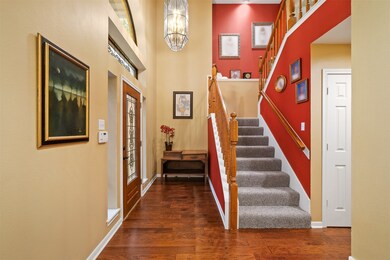 Elegant foyer features high ceilings, transom wind